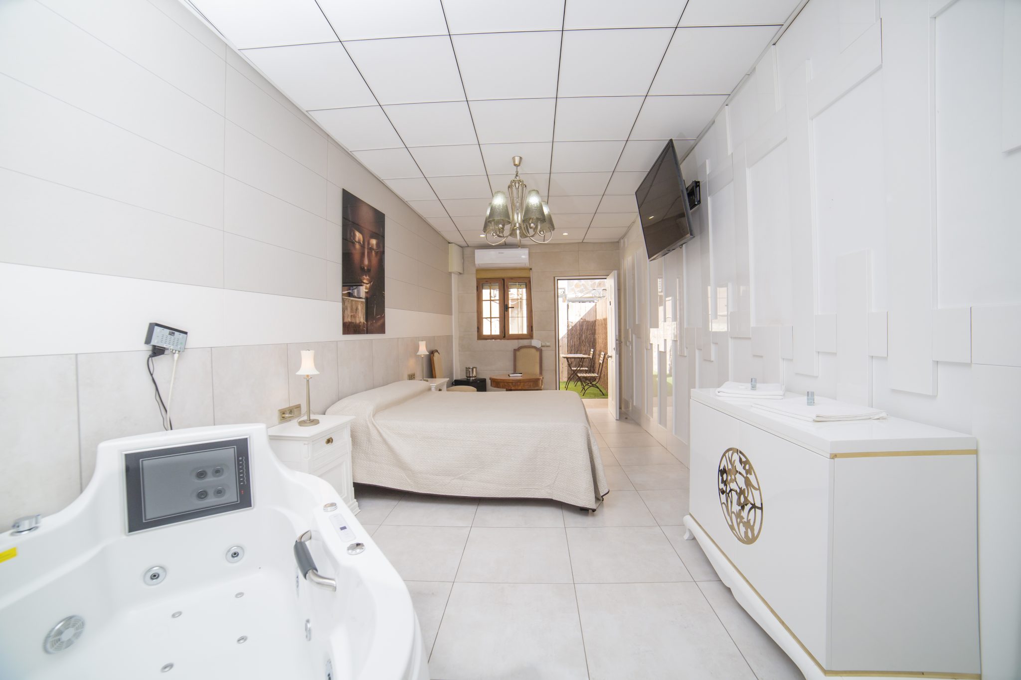 Cama de matrimonio, bañera de hidromasaje, televisión de plasma colgado en la pared