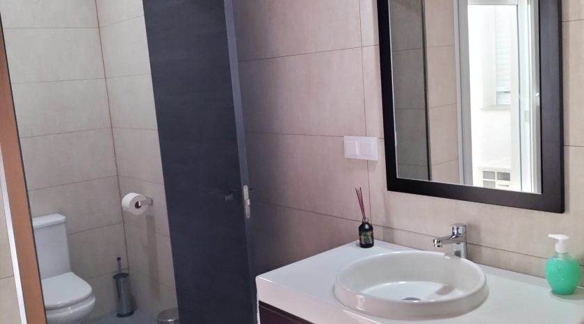 Cuarto de baño con lavamanos, espejo y váter